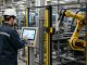 operatore e robot industriale in fabbrica
